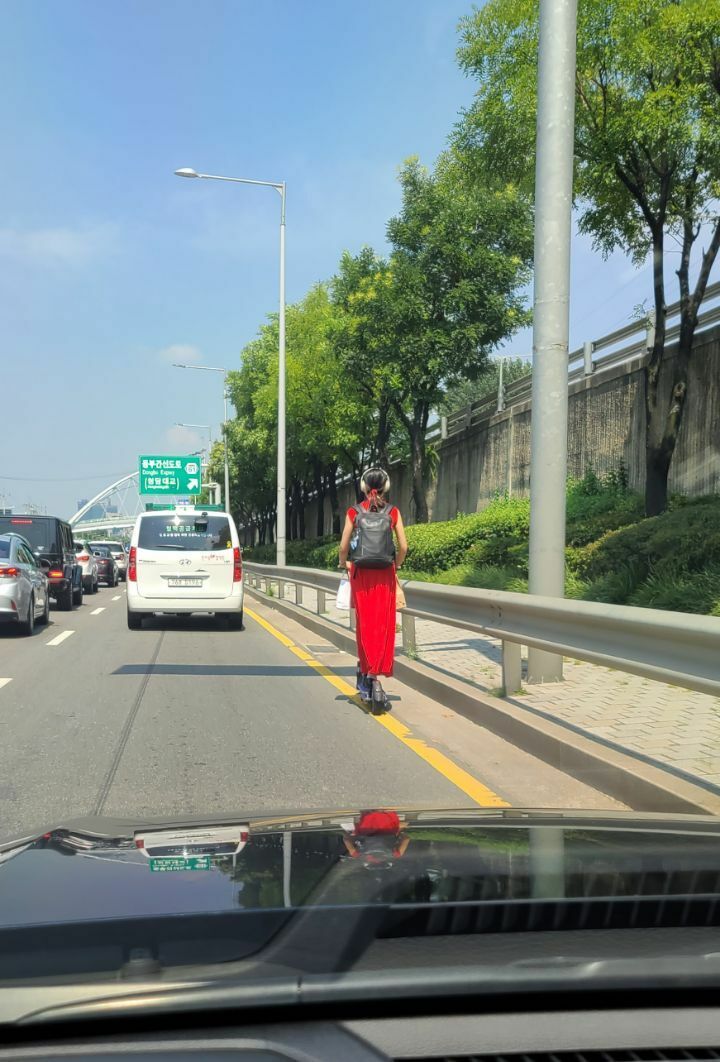 Motorized kickboard girl on the main road