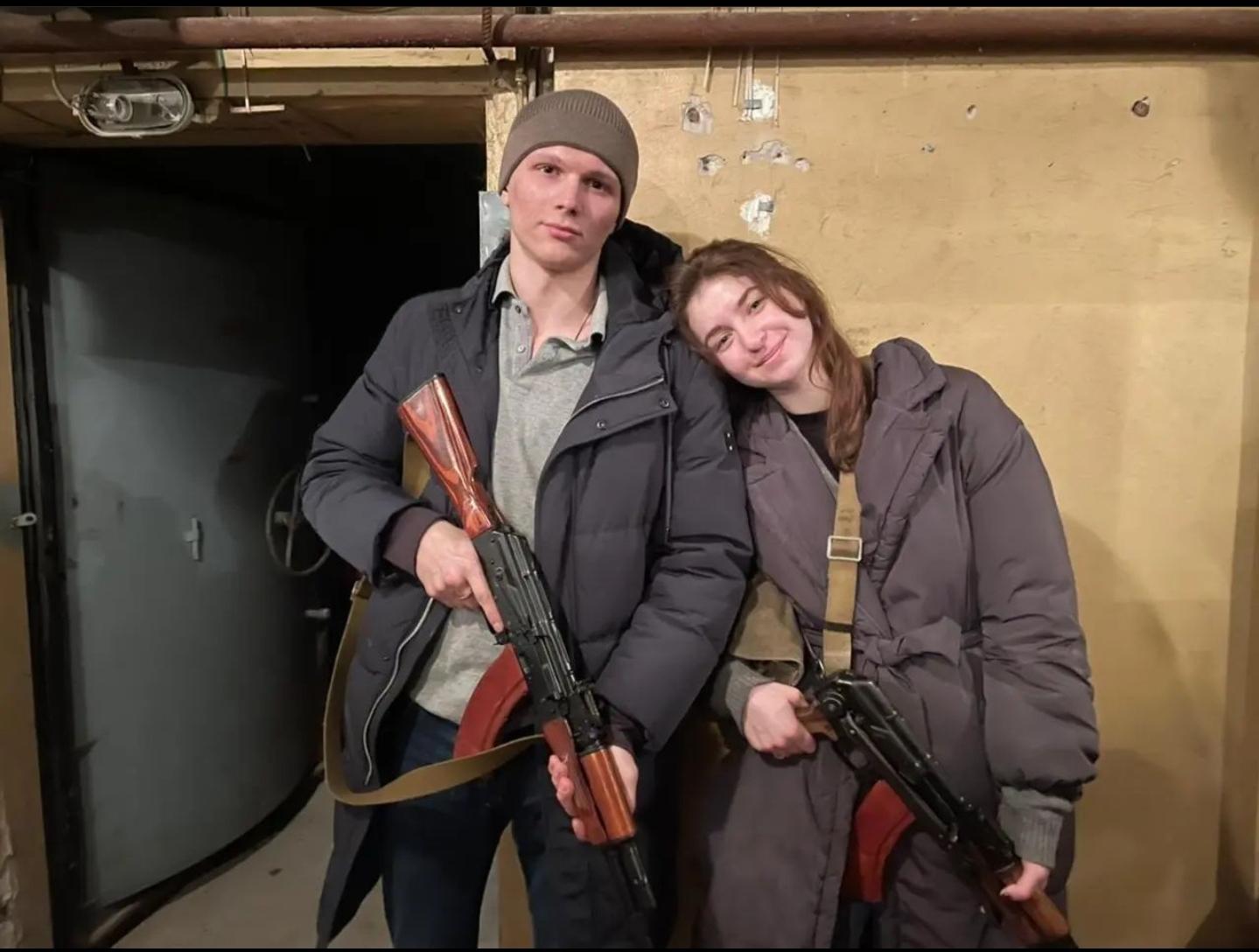 Newlywed couple with guns instead of Ukrainian wedding cake.