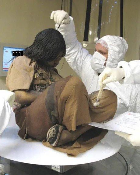 500年前に凍った死体を検査する科学者の写真